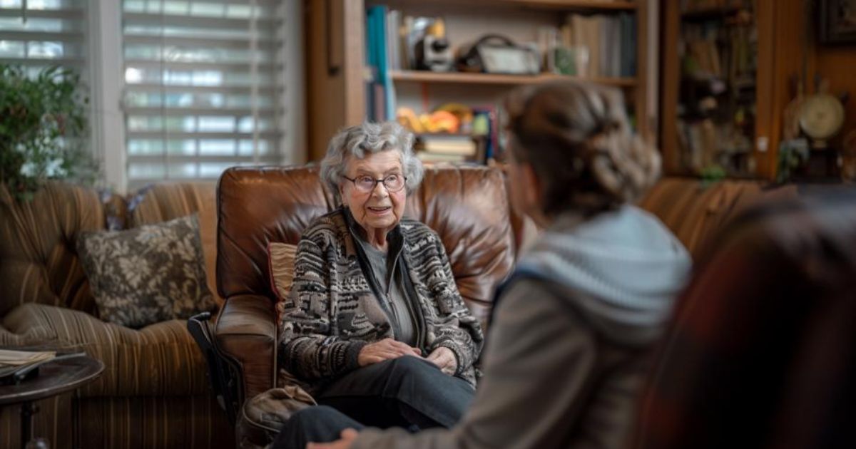 A private caregiver talks to her client, an older woman, in her home. There are pros and cons to hiring a private caregiver. Learn about the costs, risks, and benefits.