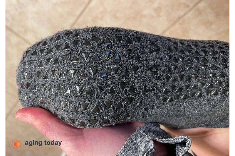A pair of non-slip socks in grey with grey triangles. Non-slip socks are essential products for caregivers to keep older adults safe.